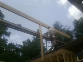 Carpenter setting a ridge beam over a new addition frame — Ice Dam Removal by Roofing Brothers in Schertz