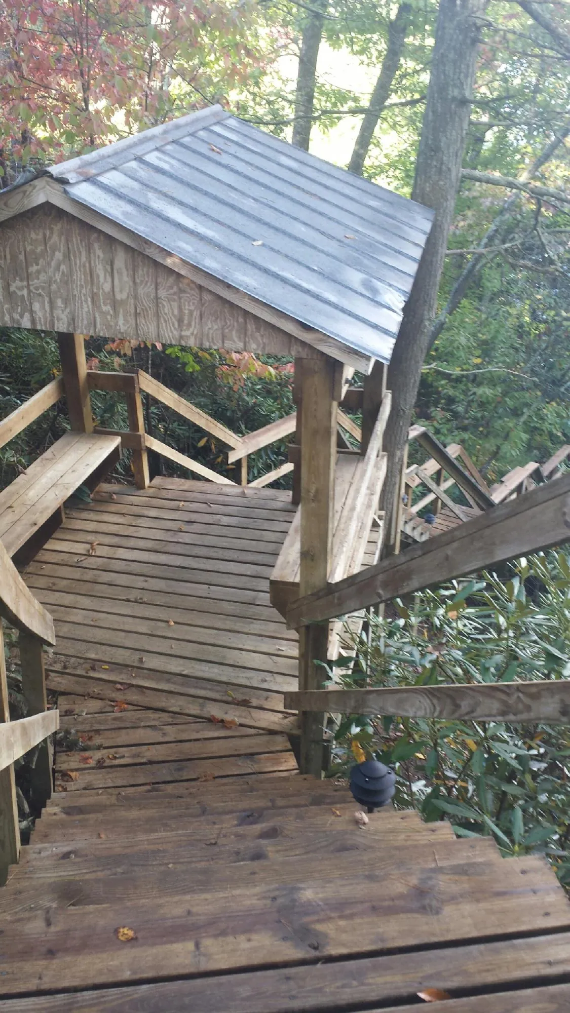 Metal roofed shelter over wooden steps on a wooded walkway — Skylight Repair & Installation work by our crew in Schertz