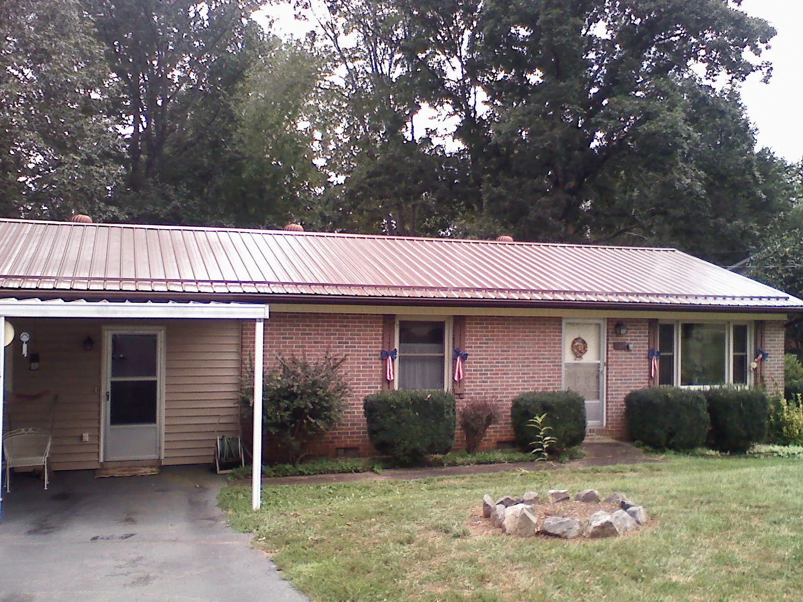 Bronze metal roof and carport on a brick ranch home — Roof Repair work by our crew in Schertz