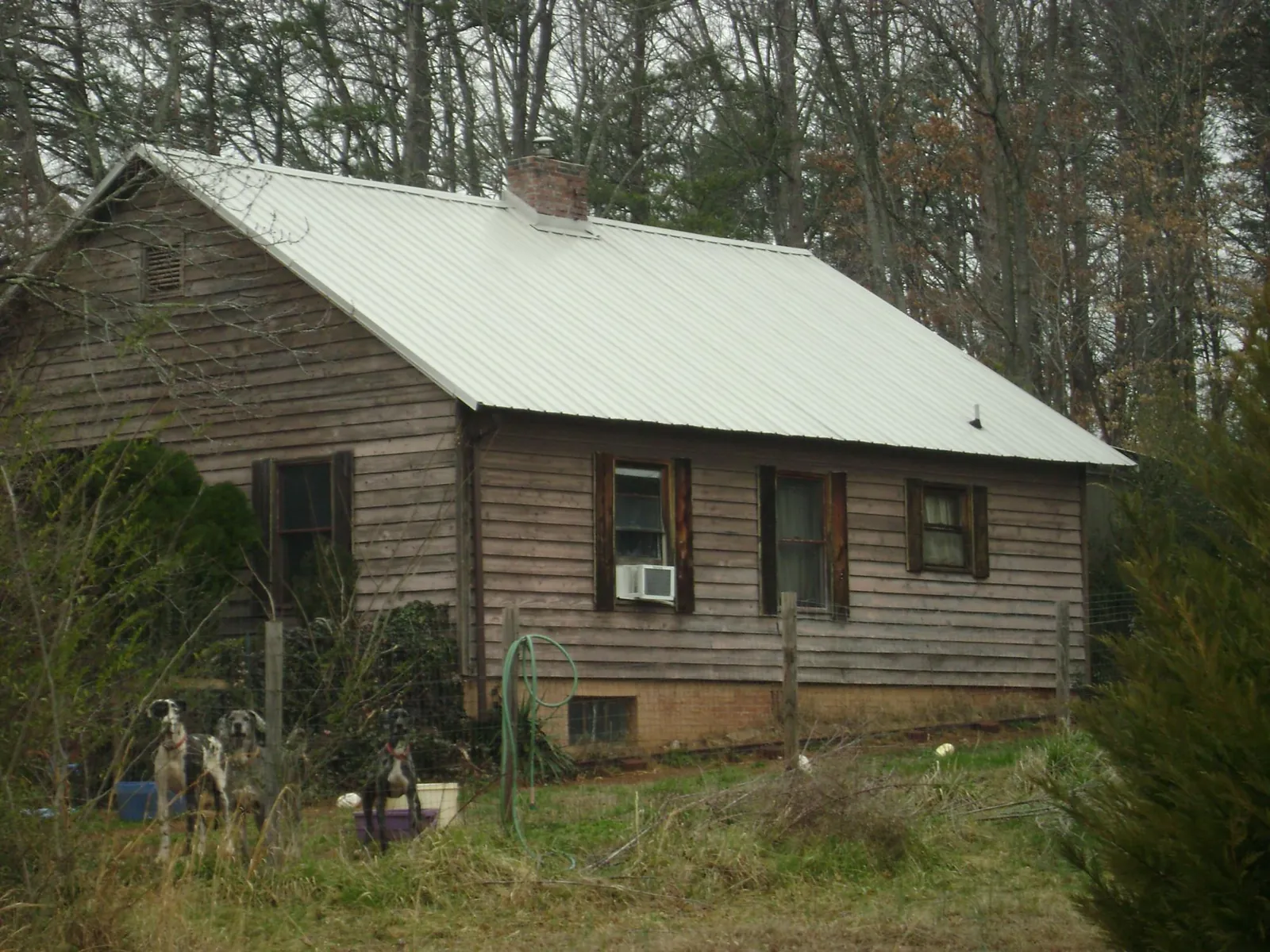 White metal roof on an old wood sided farmhouse, from a Metal Roof Installation job in Schertz